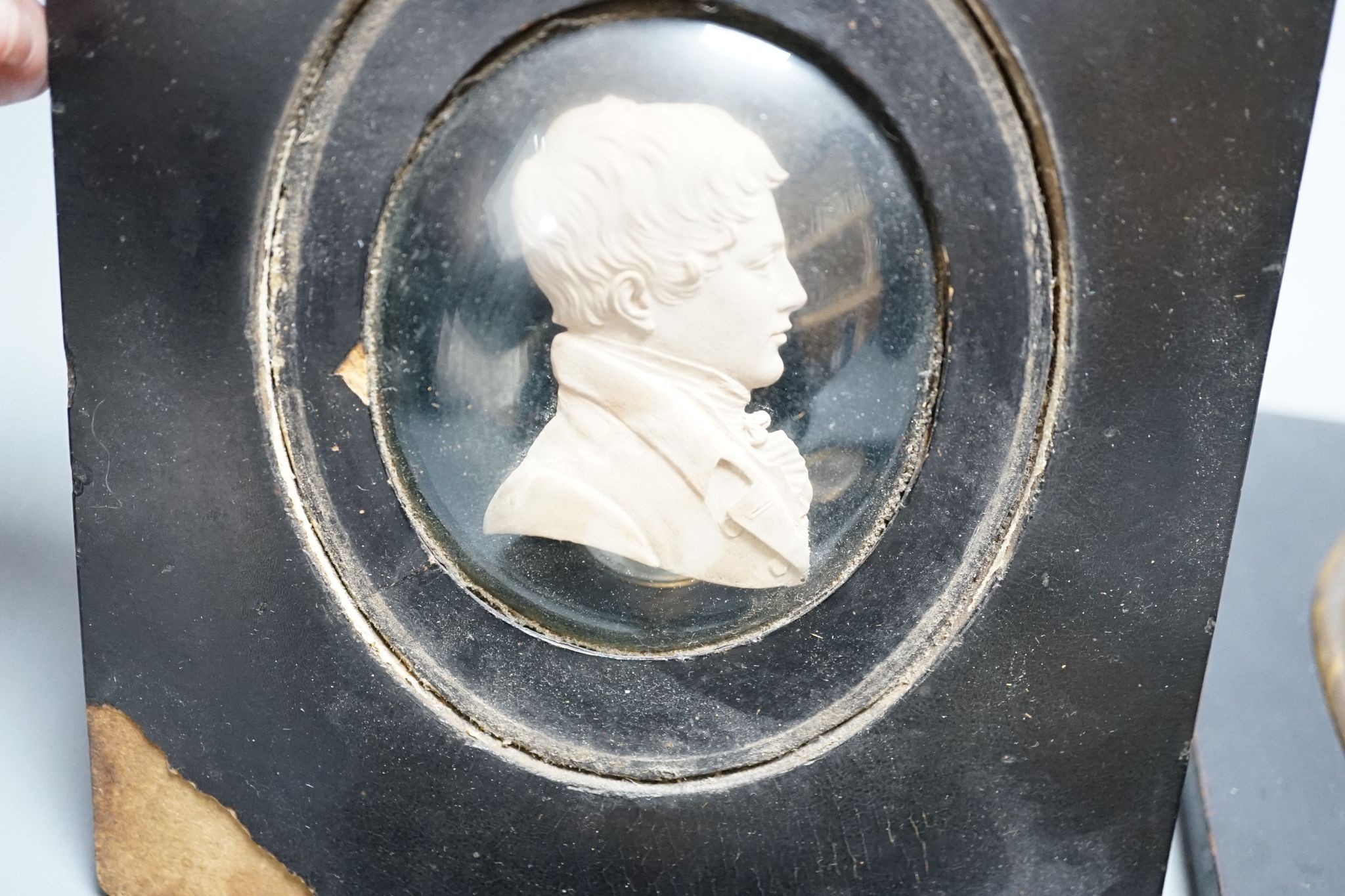 A plaster head relief and three silhouettes